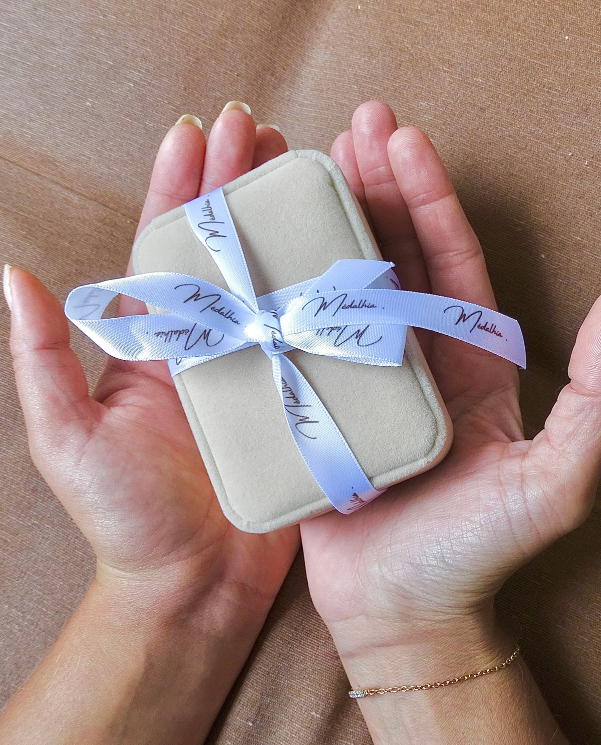 Un écrin doux qui porte votre bijou, médalhia prépare chaque création unique avec beaucoup d'amour et de passion. L'écrin est porté par les deux mains des co-fondatrice : Laura Badrous et Cécilya Jacques